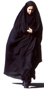 A woman in a chador mixed with modern dress underneath.